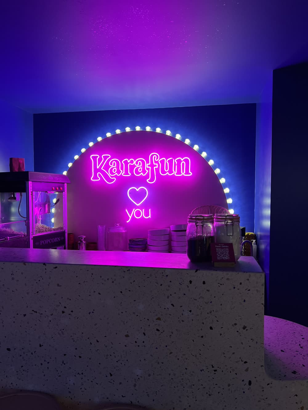 A neon 'Karafun' karaoke sign glowing pink and blue