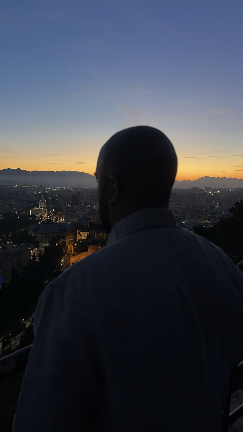 Sidarth silhouetted against a city sunset
