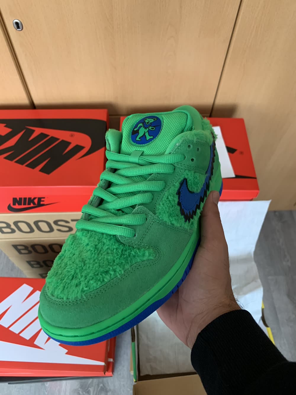 A green Nike SB Dunk sneaker held up close