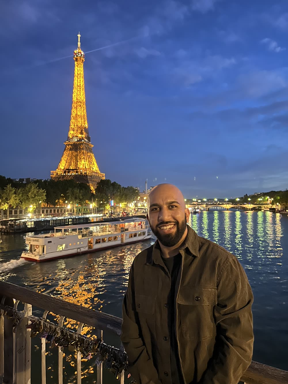 Sidarth in front of the Eiffel Tower at night in Paris
